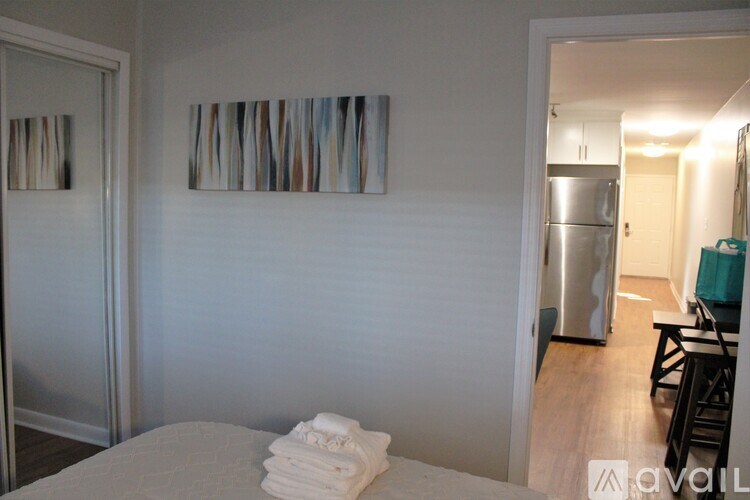 A room with a bed and a painting on the wall.