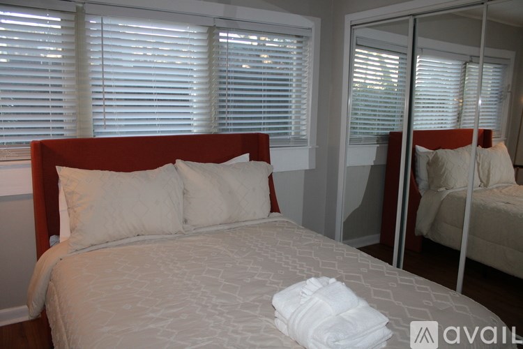 A bed with a white comforter and pillows with a towel on top of it.