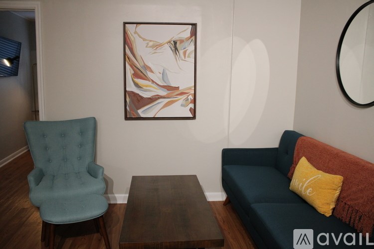 A blue chair sits in a room with a couch and a coffee table.