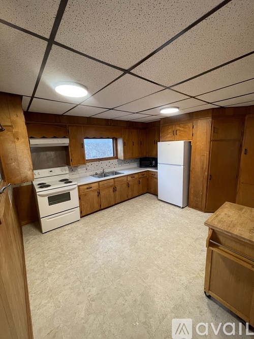A kitchen with wooden cabinets and a white refrigerator.