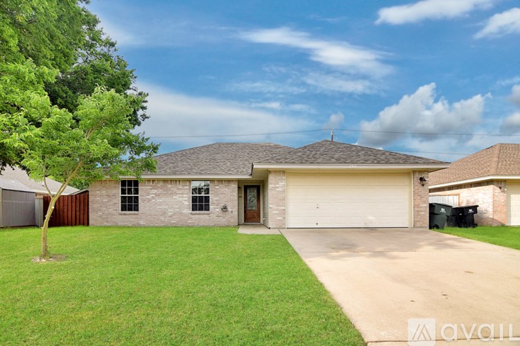A house with a garage and a tree in front.