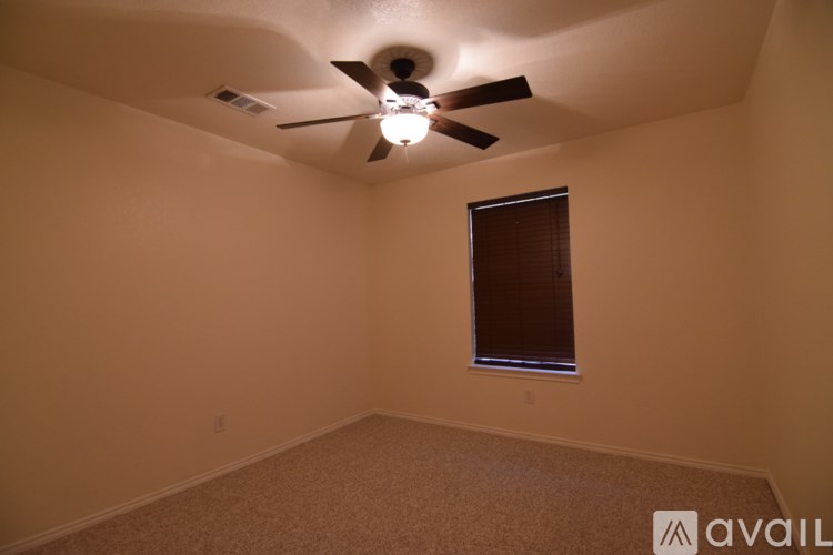 A room with a ceiling fan and a window.