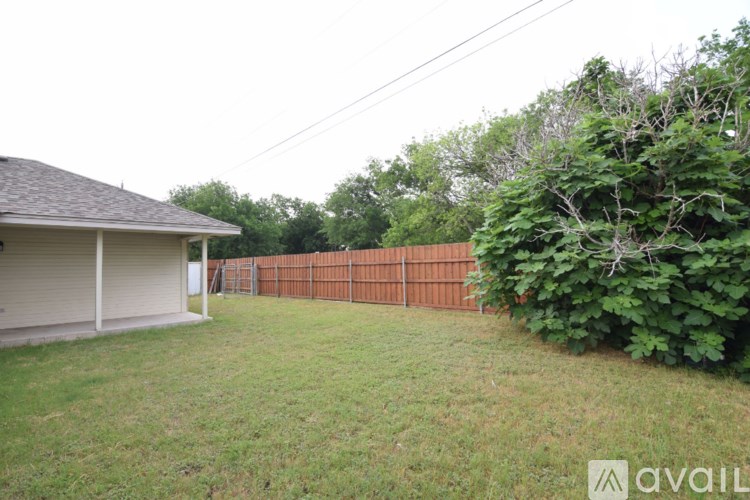 A backyard with a fence and a house.