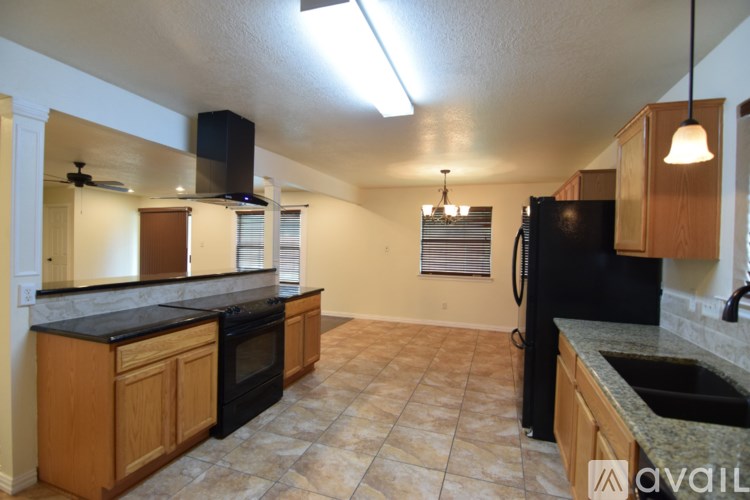 A kitchen with black appliances and wooden cabinets.