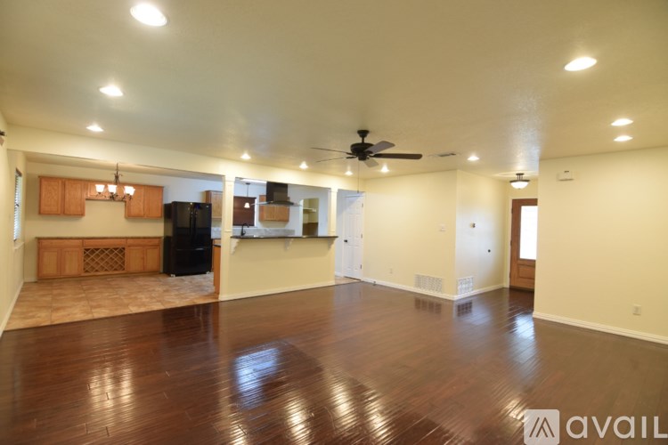 A spacious living room with hardwood floors and a ceiling fan.