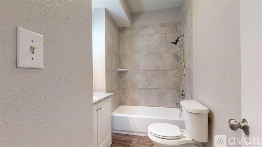 A white bathroom with a toilet, tub, and shower.