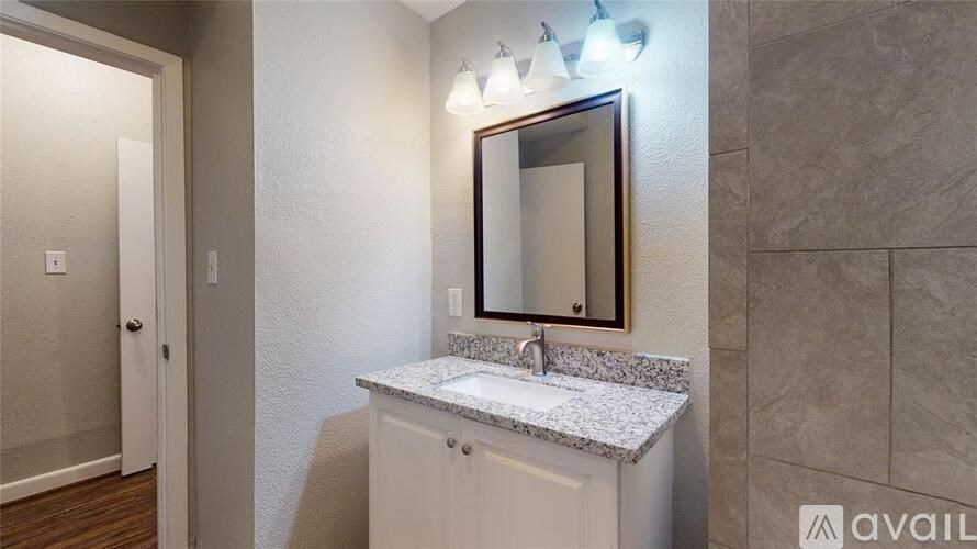 A bathroom with a white sink and a mirror above it.