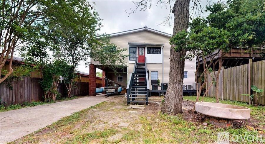 A house with a red door and a tree in front of it.