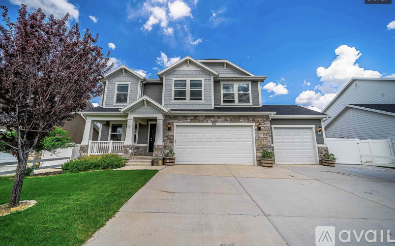 A house with a grey roof and a white garage door.