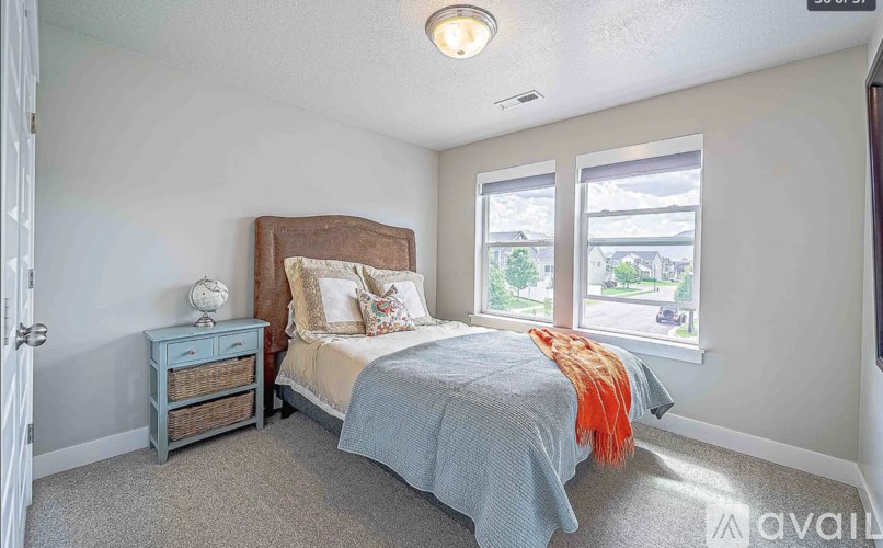 A bedroom with a bed, nightstand, and window.