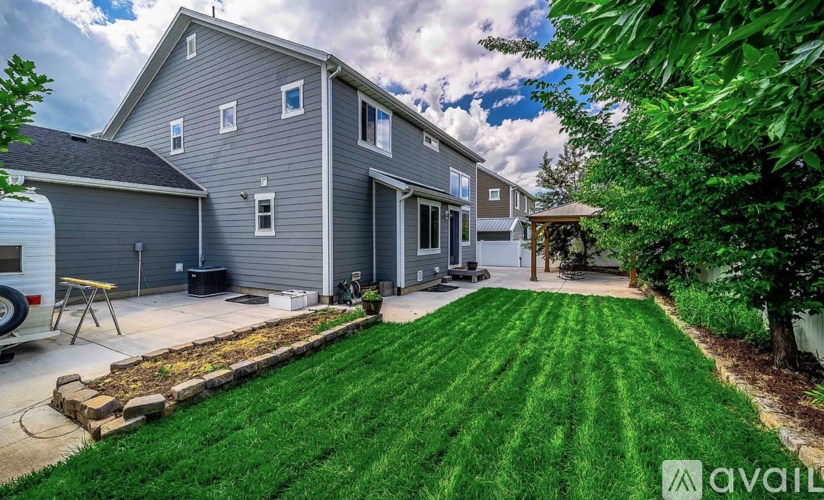 A house with a grey exterior and a green lawn.