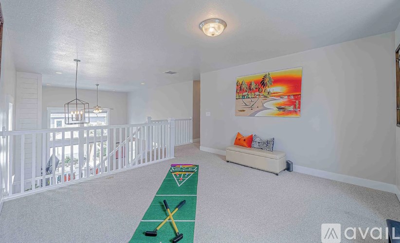 A room with a green carpet and a painting on the wall.