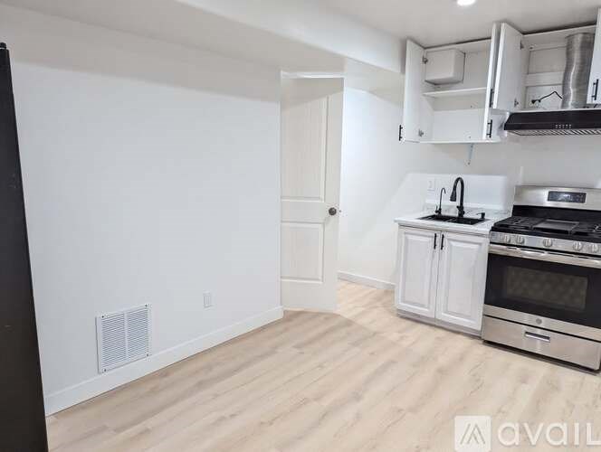 A kitchen with white cabinets and a stove top oven.