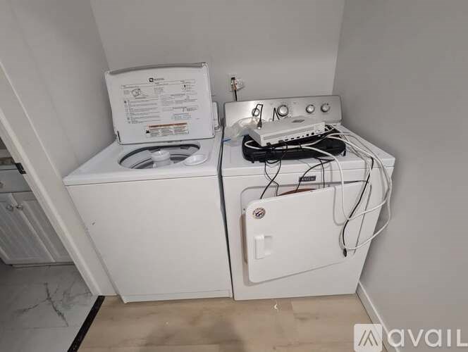 A white washing machine with a dryer on top of it.