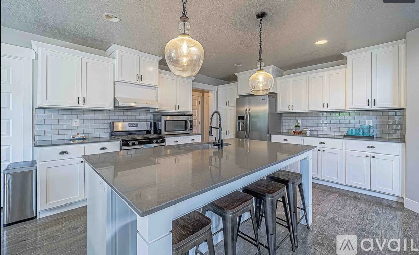 A kitchen with a large island and stools.