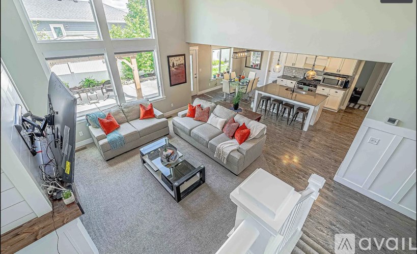 A living room with a grey carpet and white furniture.