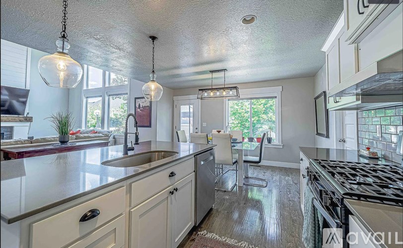 A kitchen with white cabinets and a black stove top.