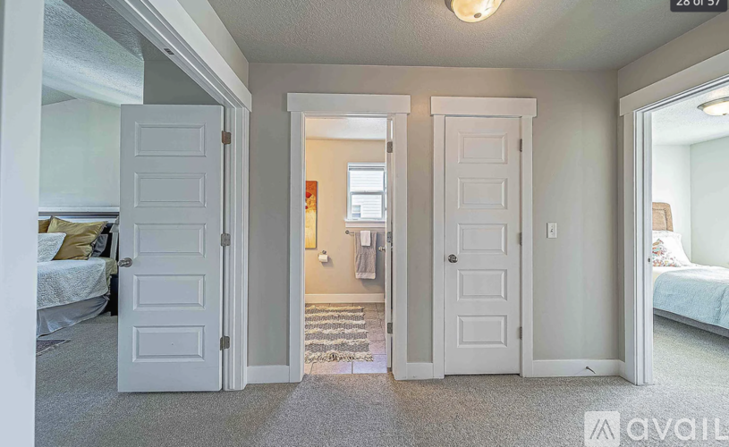 A bedroom with two doors and a carpeted floor.