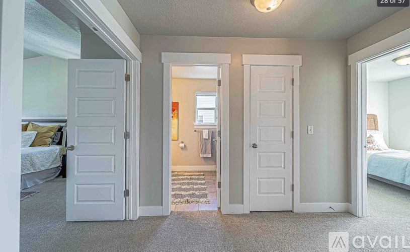 A bedroom with two doors and a carpeted floor.