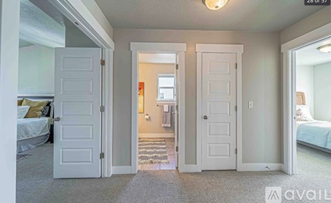 A bedroom with two doors and a carpeted floor.