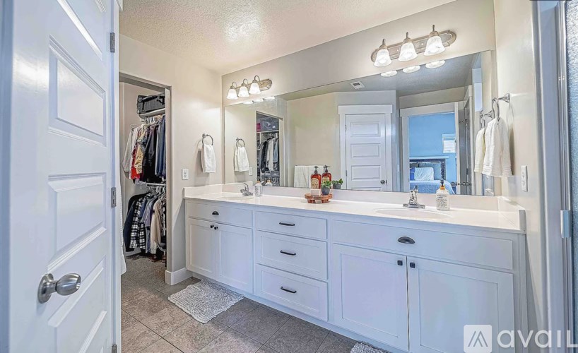 A white bathroom with a vanity and a mirror.