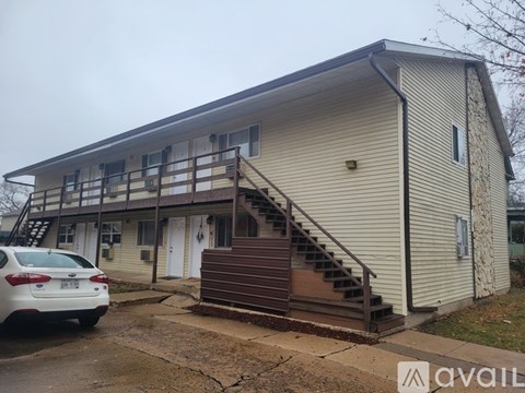 A beige house with a white car parked in front.