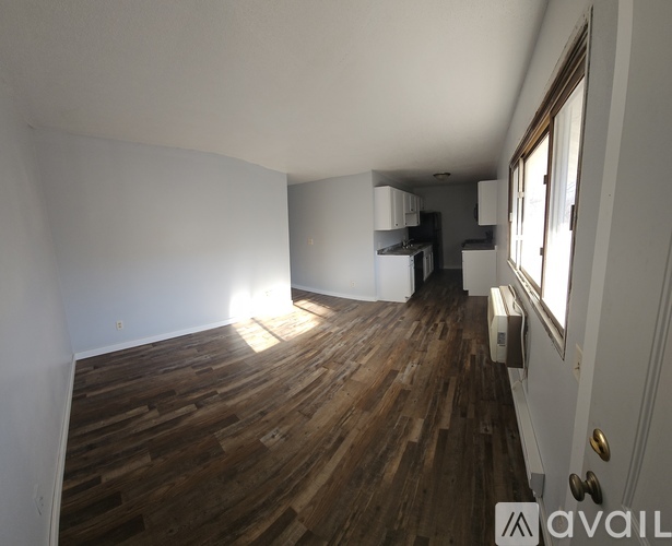 A room with wooden flooring and a window.