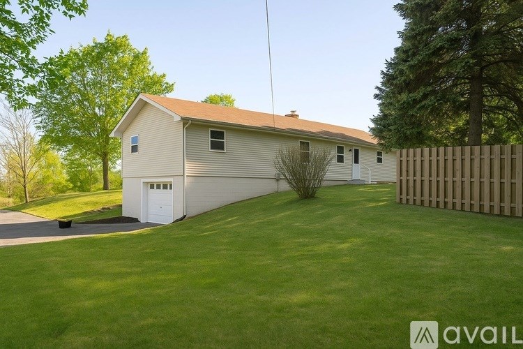 A house with a garage and a fence in front of it.