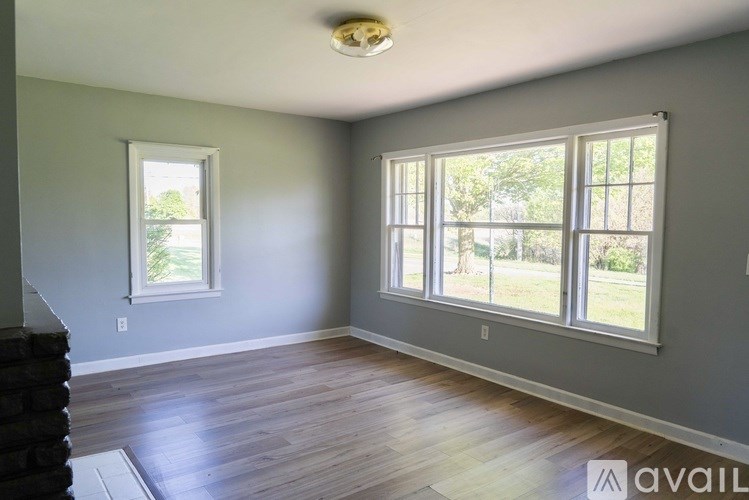 A room with a large window and a smaller window on the left wall.