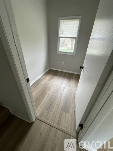 A room with a window and wooden flooring.