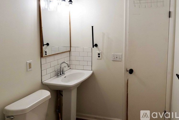 A bathroom with a white sink and a white toilet.