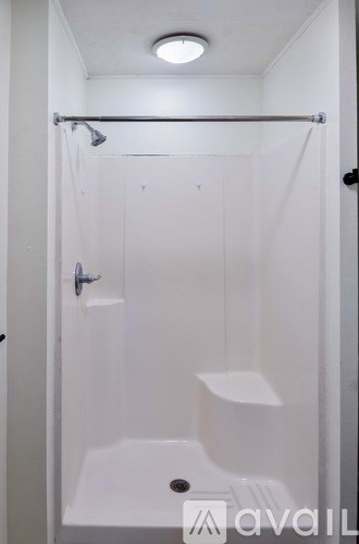 A white bathroom with a shower stall and a toilet.