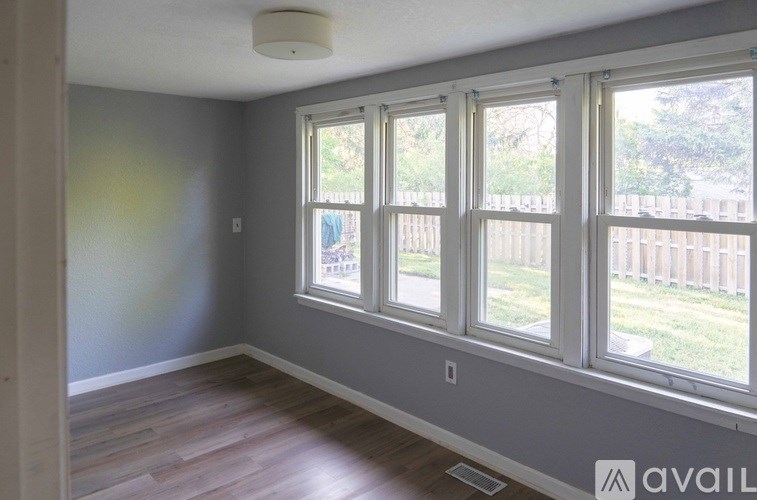 A room with a large window and wooden flooring.