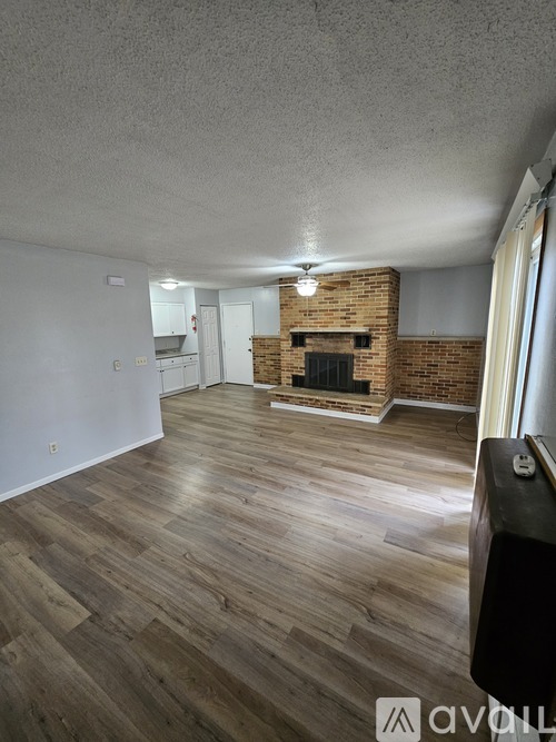 A living room with a fireplace and wood flooring.