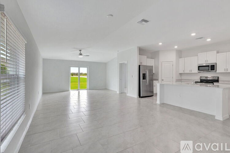 A spacious kitchen with white cabinets and a refrigerator.