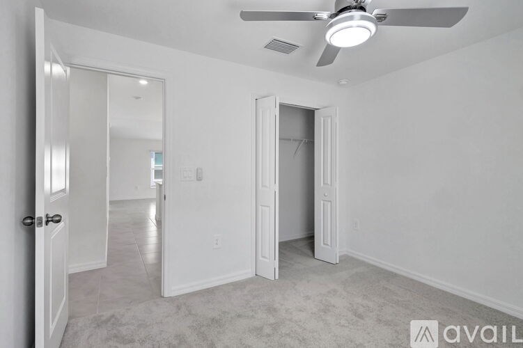 A room with a ceiling fan and two doors, one of which is open.