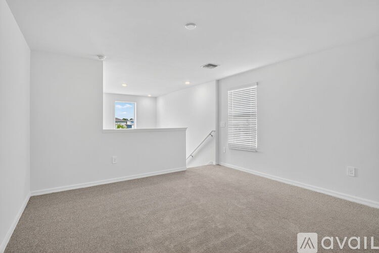 A spacious room with a ceiling fan and carpeted floor.