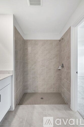 A tiled shower area in a bathroom.