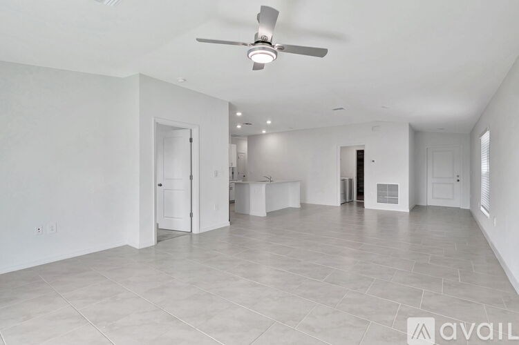 A spacious room with a ceiling fan and tiled flooring.