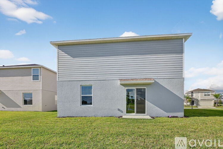 A modern house with a grey facade and a large window is for sale.