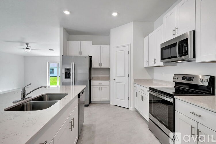 A modern kitchen with white cabinets and stainless steel appliances.