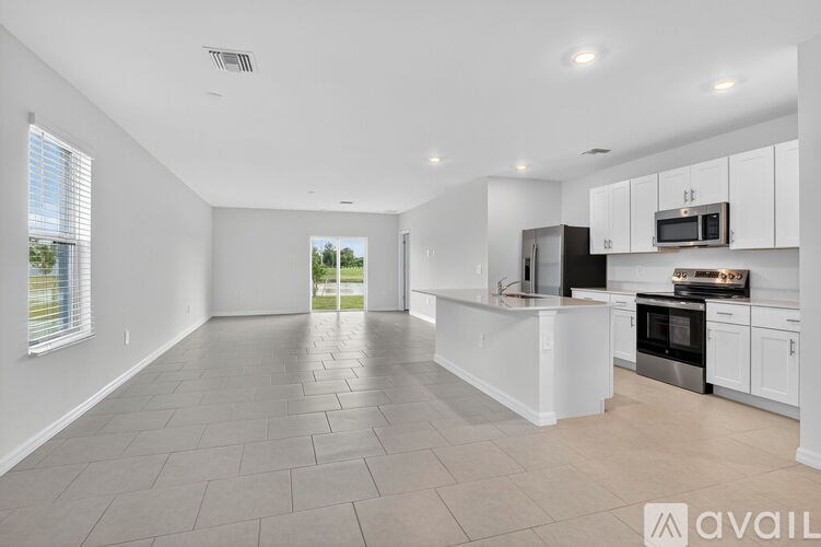 A modern kitchen with white cabinets and appliances.