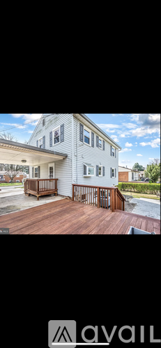 A white house with a wooden deck.