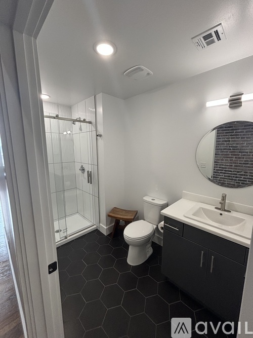 A bathroom with a toilet, sink, and shower.