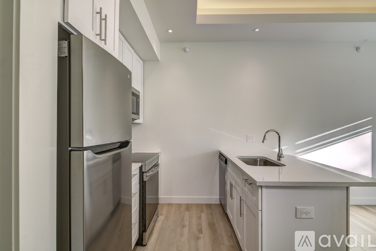 A kitchen with a stainless steel refrigerator and a sink.
