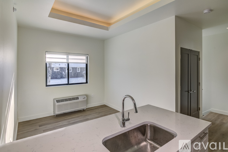 A kitchen with a sink and a window with a view of a snowy landscape.