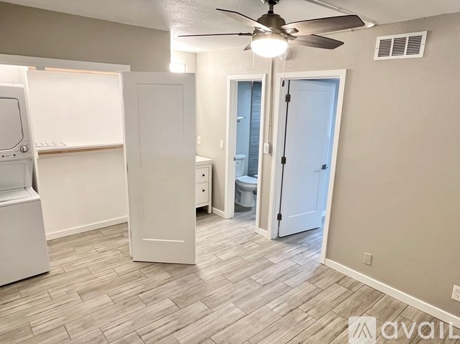 A room with a ceiling fan and a white door.