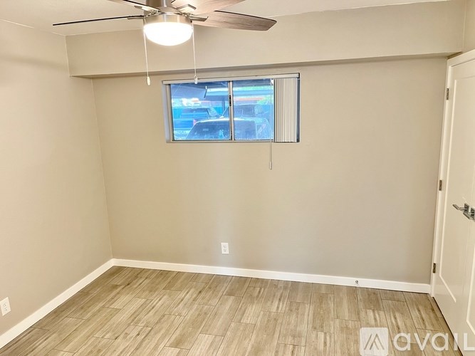 A room with a ceiling fan and a window with blinds.