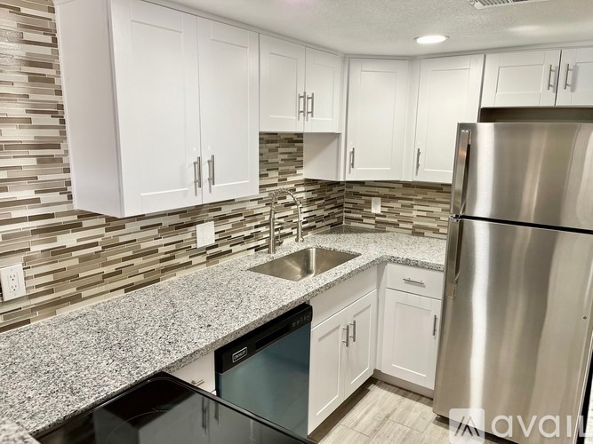 A kitchen with a granite countertop and stainless steel appliances.