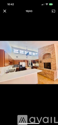 A modern kitchen with wooden cabinets and a brick fireplace.